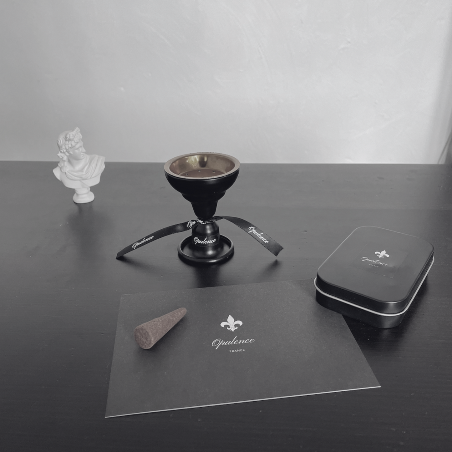 Bruleur et boîte de cônes d'encens posés sur une table avec élégance.