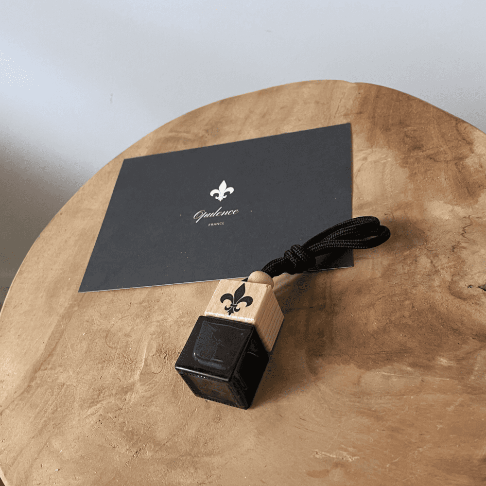 Diffuseur de parfum voiture Opulence sur une table en bois.