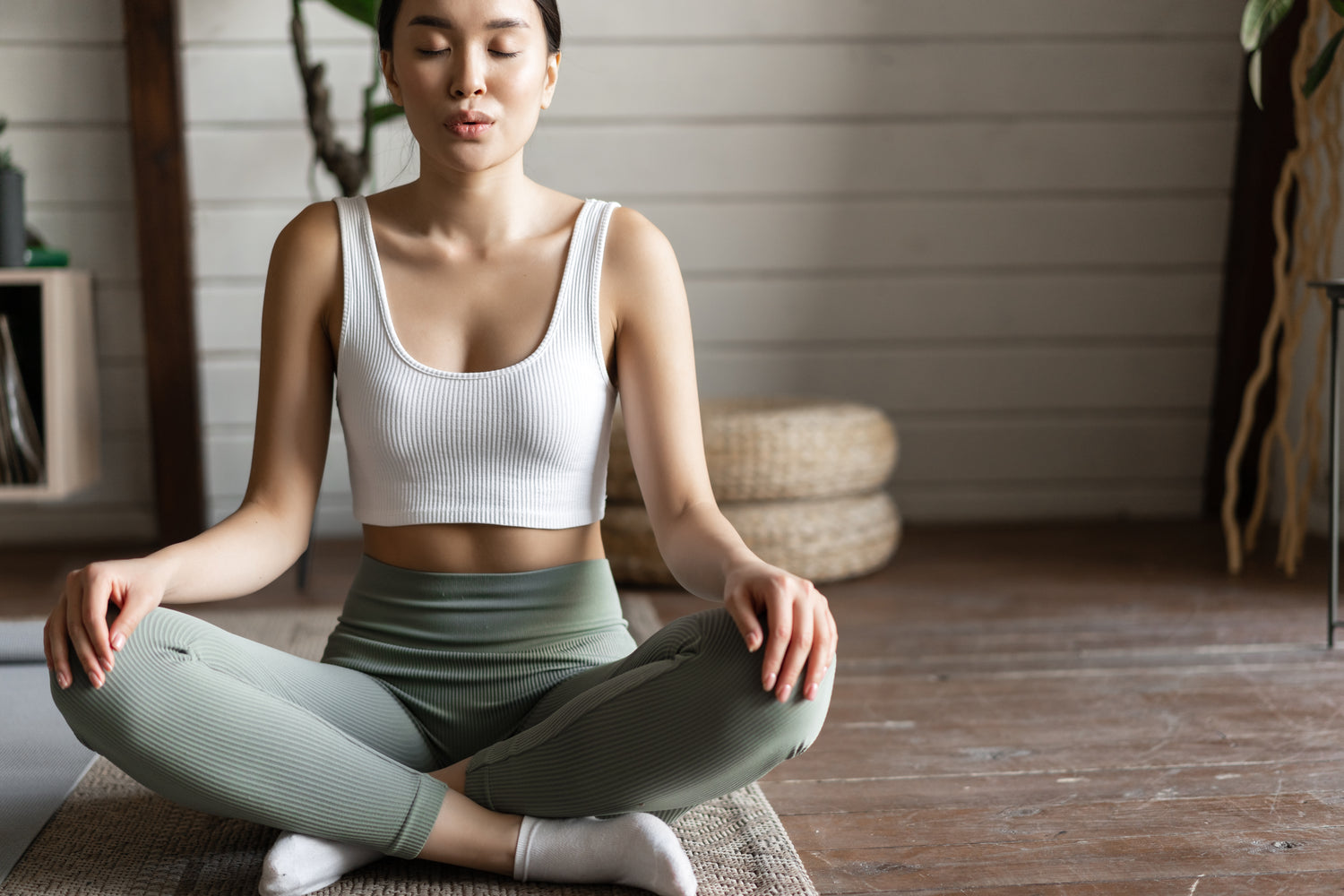 Jeune femme pratiquant du yoga dans son salon pour son bien-être