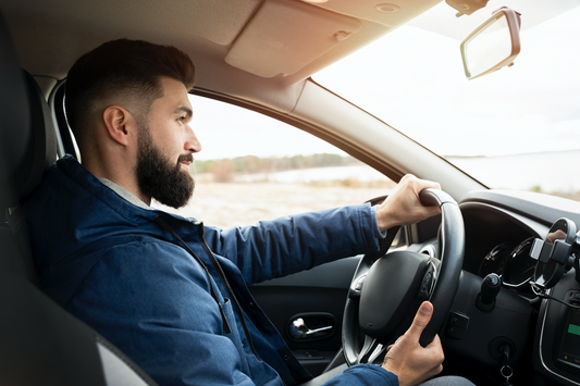 Homme au volant de son véhicule parfumé avec un diffuseur de parfum pour voiture.