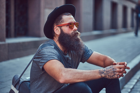 Homme assis portant une belle barbe soignée.