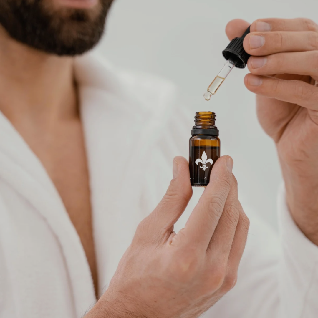 Homme barbu tenant un flacon de l'huile à barbe Opulence dans sa main.