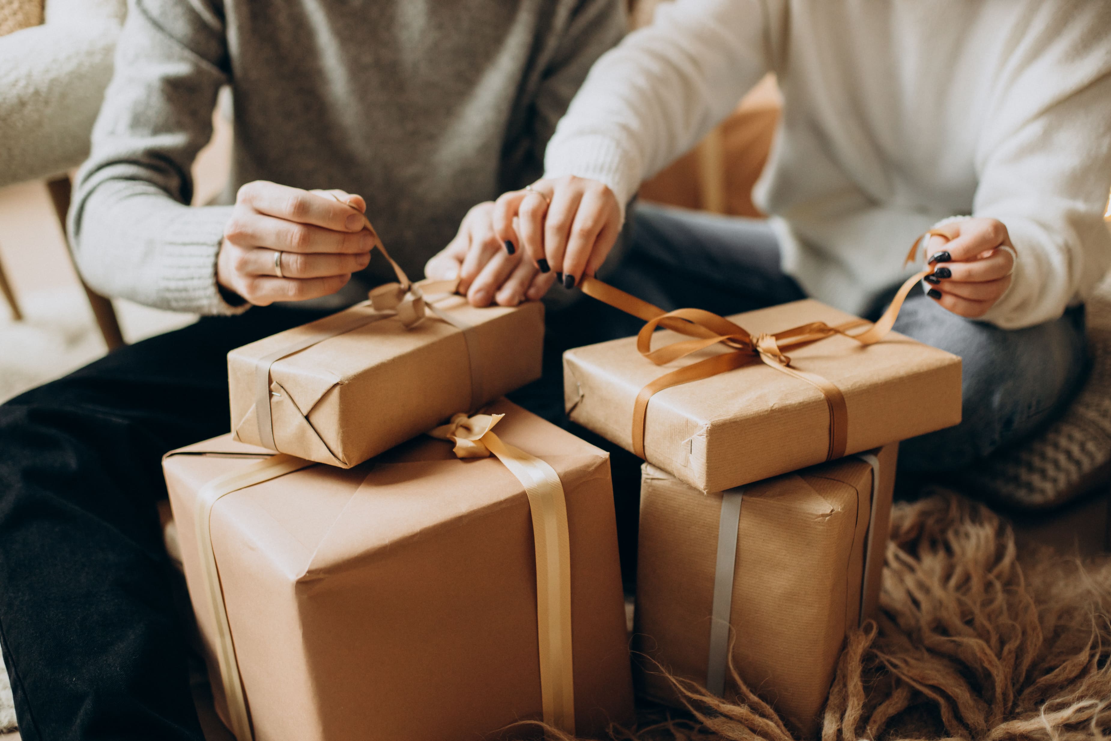 Couple ouvrant des cadeaux de noël près de leur sapin.